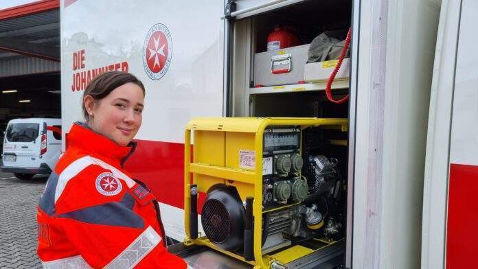 Ehrenamtliche Katastrophenschuetzerin mit Stromaggregat scaled Ehrenamtliche Katastrophenschuetzerin mit Stromaggregat scaled