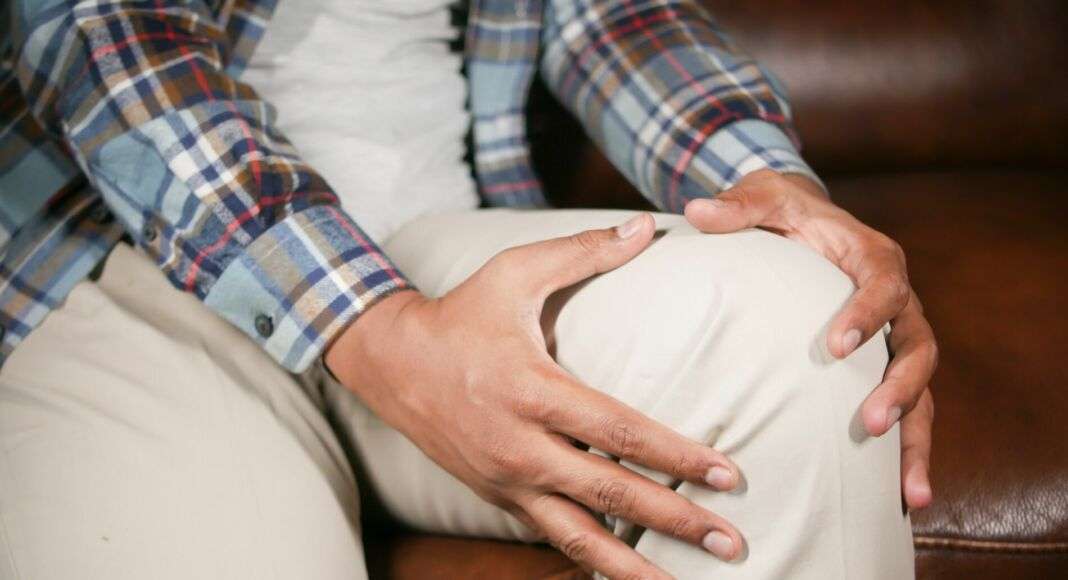 Knieschmerzen Person hält ihr schmerzendes Knie