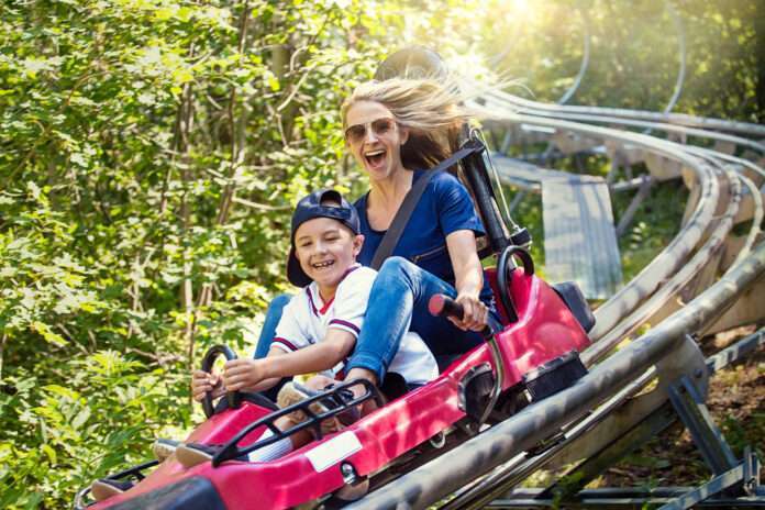 Woman and boy enjoying a summer fun roller coaster ride
