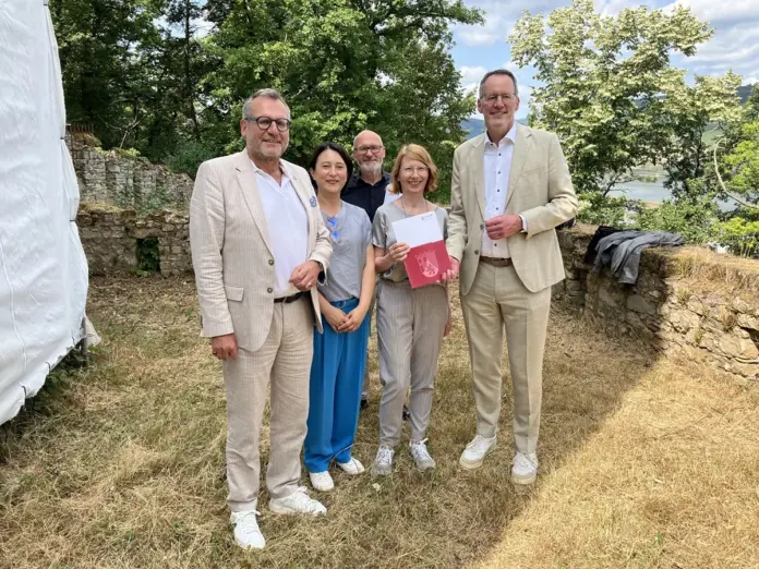 Oberbürgermeister Thomas Feser, Alexandra Fischer-Raabe, Leiterin Kulturzentrum Villa Sachsen, Architekt Hubertus Jäckel, Carola de Decker, Generalsekretärin der Soka Gakkai in Deutschland und Minister Michael Ebling bei der Bescheidübergabe. Quelle: Stadt Bingen / Foto: Markus Hembes 210.000 Euro Landesförderung erhält das Kulturzentrum Villa Sachsen in Bingen für die Sanierung der Burgruine im Hanggarten. Zur feierlichen Bescheidübergabe auf dem Gelände war auch Oberbürgerbürgermeister Thomas Feser eingeladen. Seit vielen Jahren schon besteht zwischen der Stadt Bingen und der Soka Gakkai als Trägergemeinschaft des Kulturzentrums Villa Sachsen eine enge Partnerschaft – zum Beispiel durch die Binger