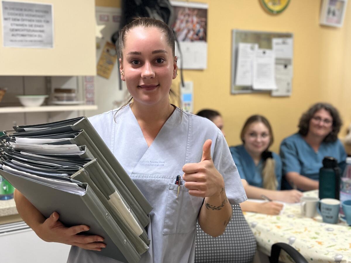 Schichtwechsel: Auch die Übergabe muss für eine sichere Patientenversorgung geübt werden. Larissa Berger übergibt die Patientenakten an die Kollegen des Spätdienstes. Foto: Stiftung kreuznacher diakonie, Sandra Beck